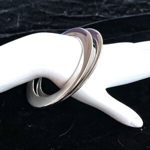 Pair of shiny sleek thin silver flat bangle bracelets elegant accessory
